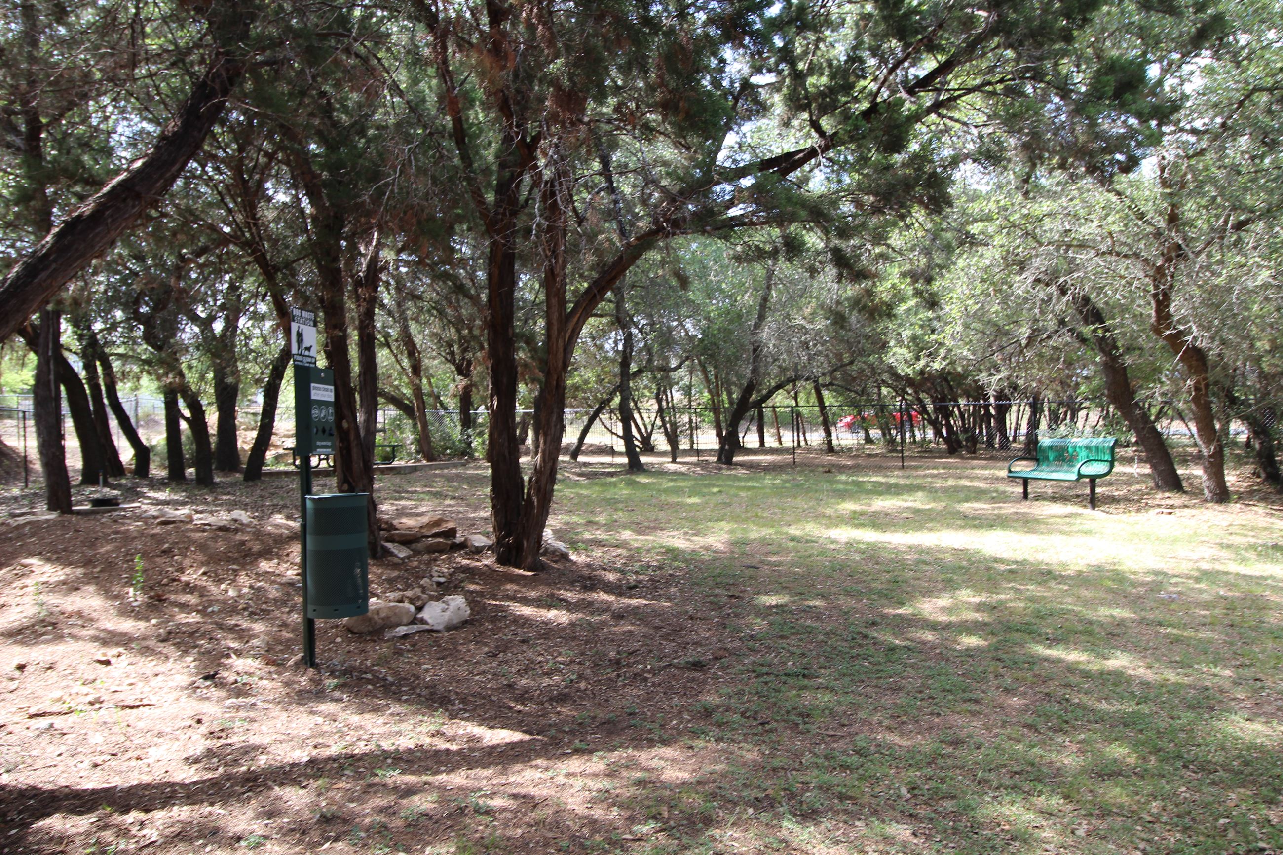 The small dog park, with plenty of room to explore and a bench for human companions.